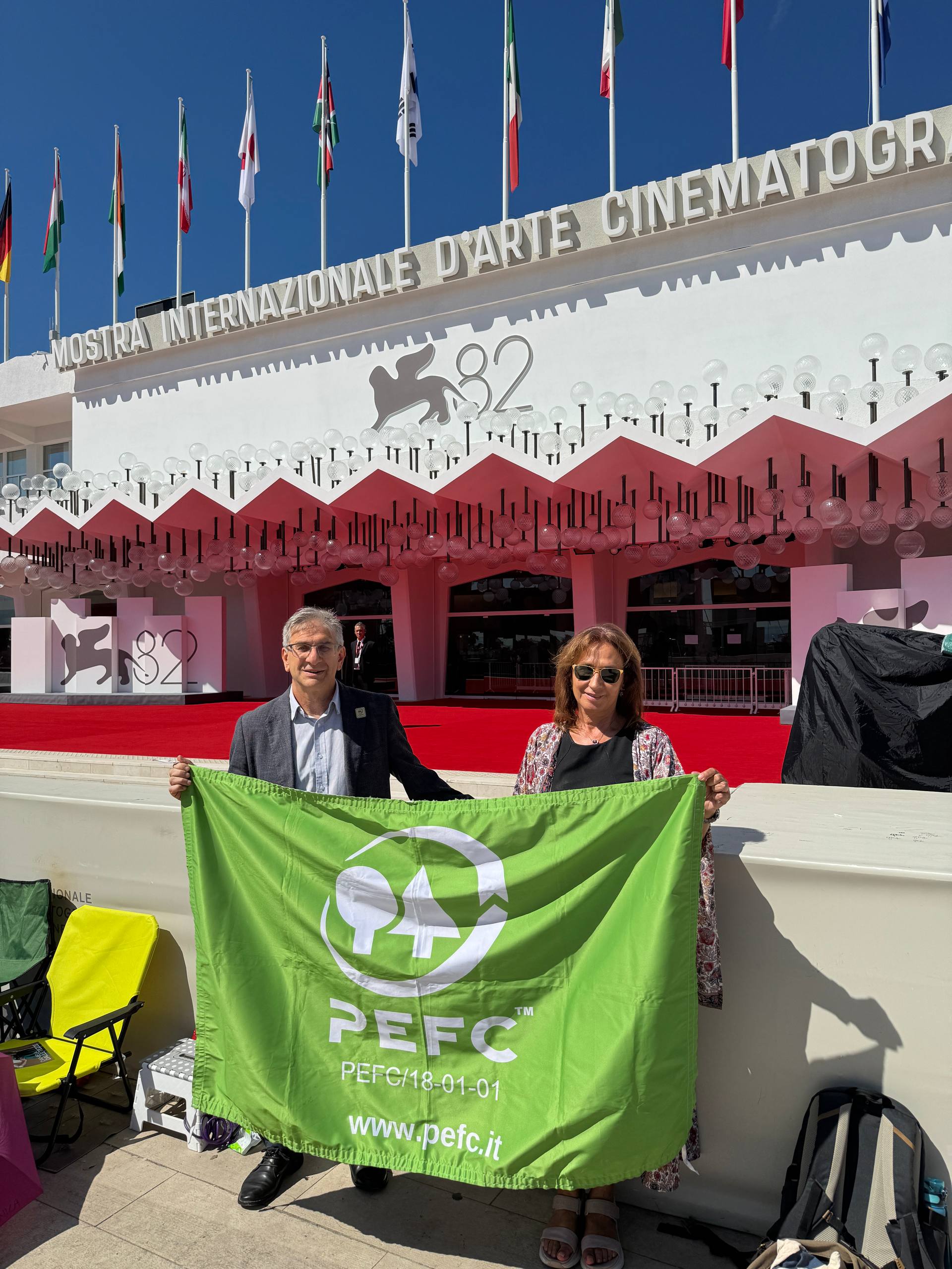 PEFC Italy and PEFC Spain holding a PEFC flag outside the Venice International Film Festival